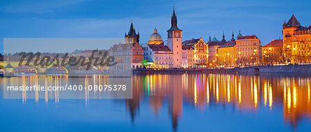 Panoramic image of Prague riverside and Charles Bridge, with reflection of the city in Vltava River.