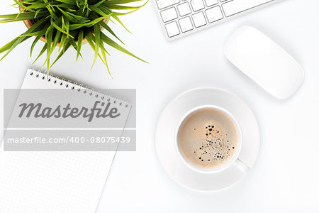 Office desk table with computer, supplies, coffee cup and flower. Top view with copy space