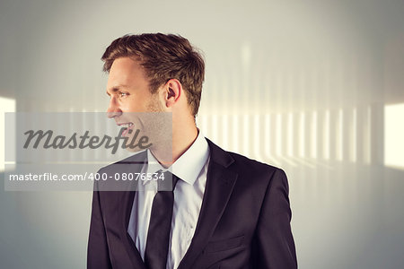 Young handsome businessman looking away against white curved room with light