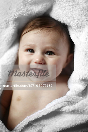 Portrait of a 4 months old baby naked in a towel