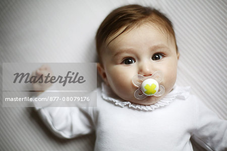 Portrait of 4 months baby girl with a dummy