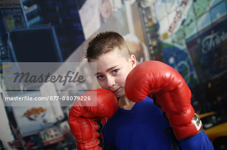 A 10 years old boy posing with boxing gloves