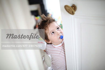 little boy opening the door of his room