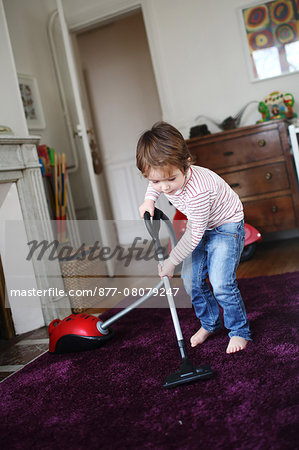 Little boy using vacuum cleaner