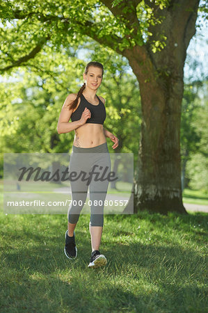 Close-up of a young woman exercising, running in a park in spring, Bavaria, Germany