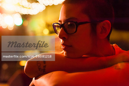 Portrait of punk girl, resting head on arms, pensive expression