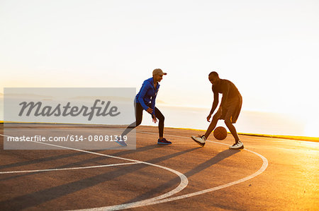 Two friends playing basketball, outdoors