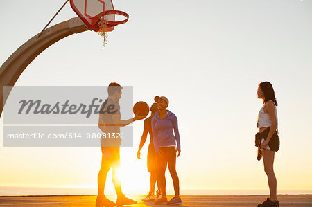 Group of friends playing basketball, outdoors