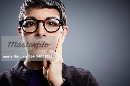 Studio portrait of mature businesswoman hand on cheek Studio portrait of mature businesswoman hand on cheek