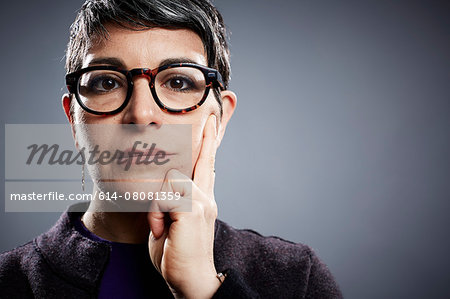 Studio portrait of mature businesswoman hand on cheek