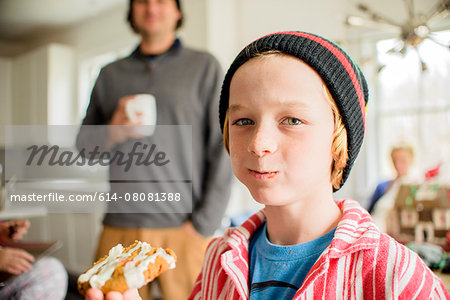 Portrait of boy eating cake in kitchen