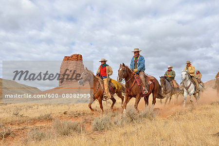 Cowboys and Cowgirls Riding Horses with Castel Rock in the background, Shell, Wyoming, USA