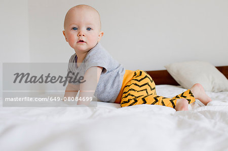 Portrait of baby girl crawling on bed