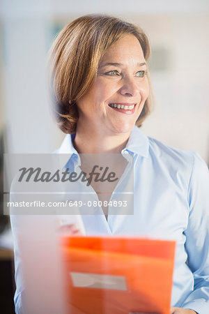 Mature businesswoman with smartphone and paperwork