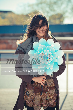 Portrait of mid adult woman with flower windmill