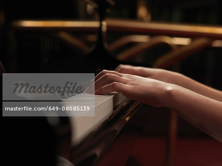 Close up of girls hands playing piano keys