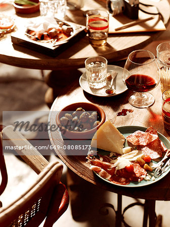 Tables with antipasto starters with olives, chorizo, salami, cheese,  parma ham with beer and wine