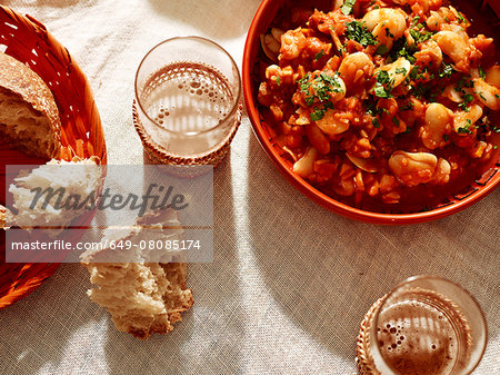 Bowl of white bean stew with bread and beer