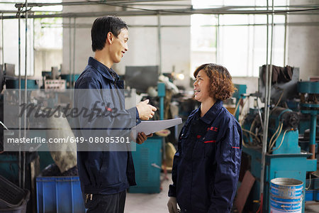 Supervisor explaining to worker in crane factory, Jiangsu Province, China