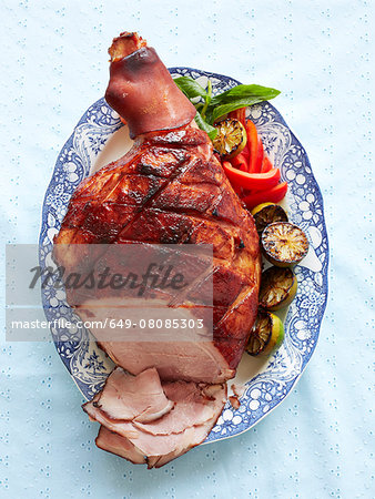 Still life with plate of baked creole ham and vegetables