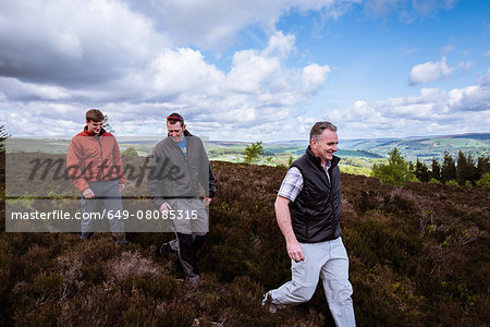 Male friends hiking on heather moors, Pateley Bridge, Nidderdale, Yorkshire Dales