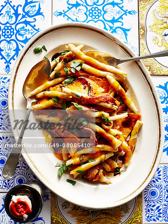 Still life with dish of Italian pumpkin and bacon strozzapetti