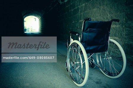 Empty wheelchair in dark tunnel