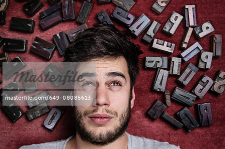 Young man with letterpress letters surrounding his head