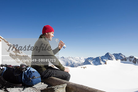 Male hiker drinking water on viewing platform, Jungfrauchjoch, Grindelwald, Switzerland