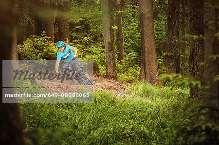 Young man mountain biking in forest