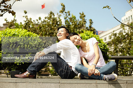 Couple sitting on wall, The Bund, Shanghai, China