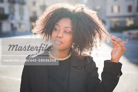 Portrait of young woman looking away in town square