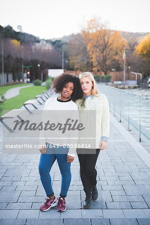 Portrait of two young female friends in lakeside park, Como, Italy