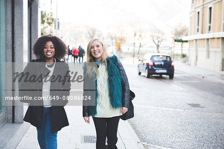 Portrait of two young female friends strolling along street, Como, Italy