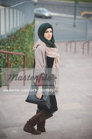 Portrait of young woman wearing hijab on stairway