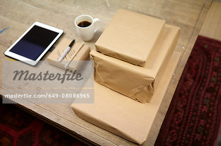 Still life of parcels and digital tablet in picture framers workshop