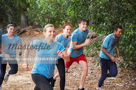 Smiling team running on boot camp obstacle course