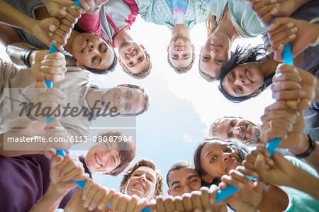 Portrait of team connected in circle around plastic hoop Portrait of team connected in circle around plastic hoop