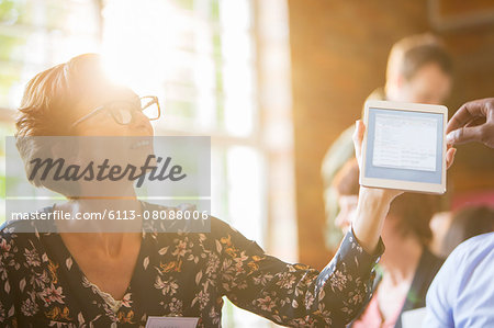 Woman using digital tablet in sunny meeting