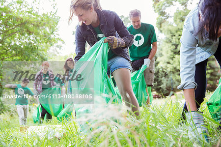 Environmentalist volunteers picking up trash in field