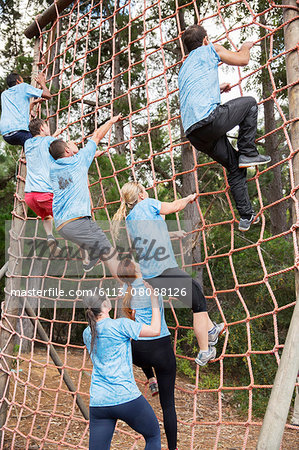 People climbing net on boot camp obstacle course