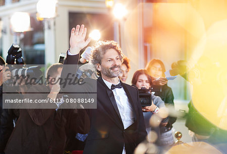 Celebrity waving for paparazzi at event