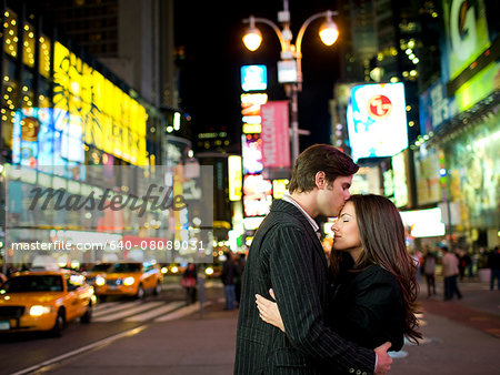 USA, New York, New York City, Manhattan, Times Square, young couple embracing in street