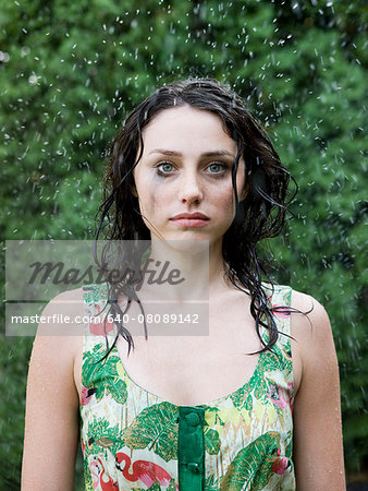 woman in a dress standing in the sprinklers