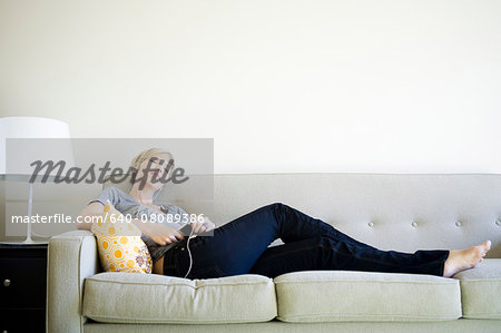 woman sitting on couch listening to an iPod