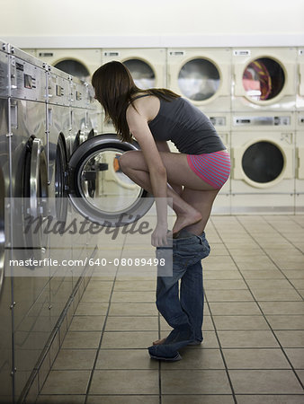 woman taking off her clothes at the laundromat