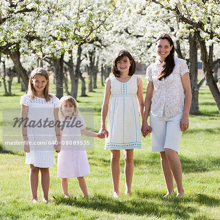 mother and three daughters in an orchard