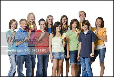 teenagers holding pieces of fruit except for the girl in the middle with a cookie