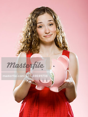 woman holding a broken piggy bank