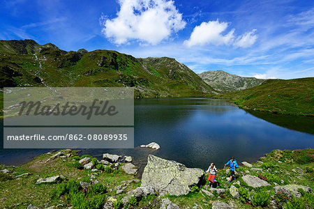 Hikers on the Lower Wildalmsee on the way to Schafsiedel, Kelchsau, Kitzbuhel Alps, Tyrol, Austria, Europe, MR